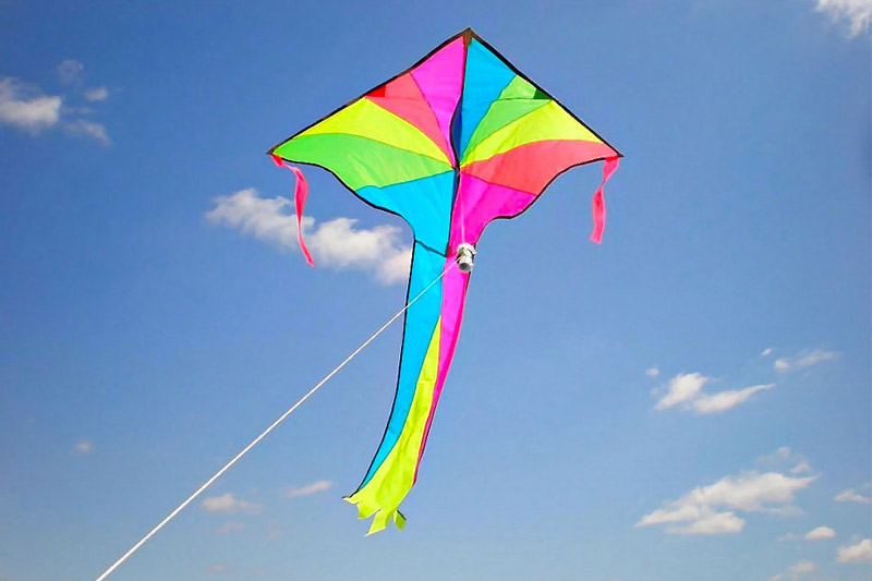 L’immagine mostra un aquilone
              colorato che vola nel cielo azzurro